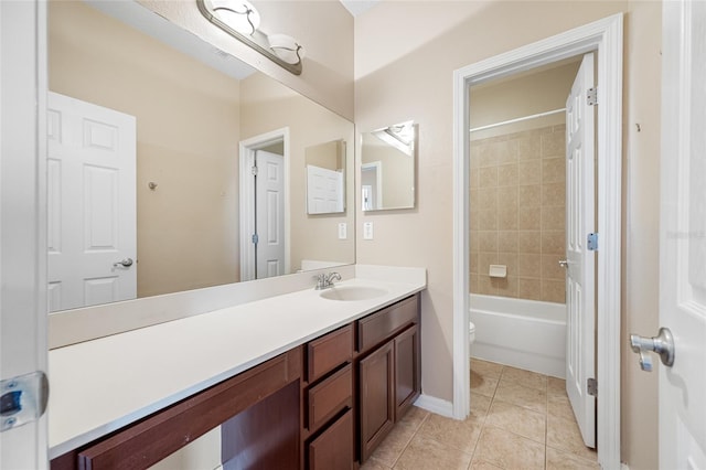 full bathroom with tile patterned flooring, vanity, tiled shower / bath, and toilet