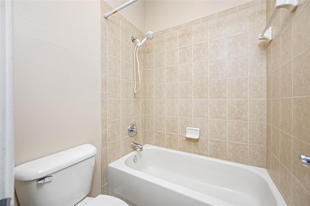 bathroom with tiled shower / bath and toilet