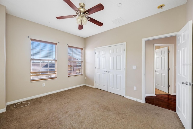 unfurnished bedroom with ceiling fan, carpet flooring, and a closet