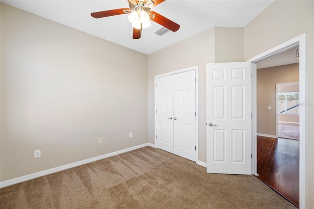 unfurnished bedroom with ceiling fan, a closet, and carpet