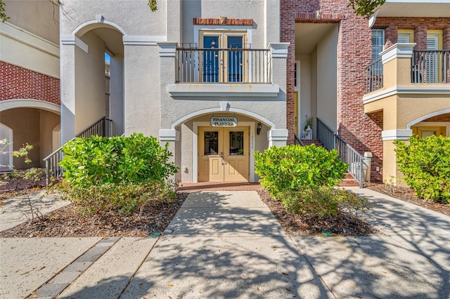 doorway to property featuring a balcony and french doors