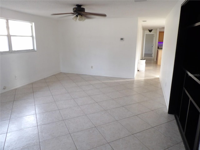 tiled empty room featuring ceiling fan