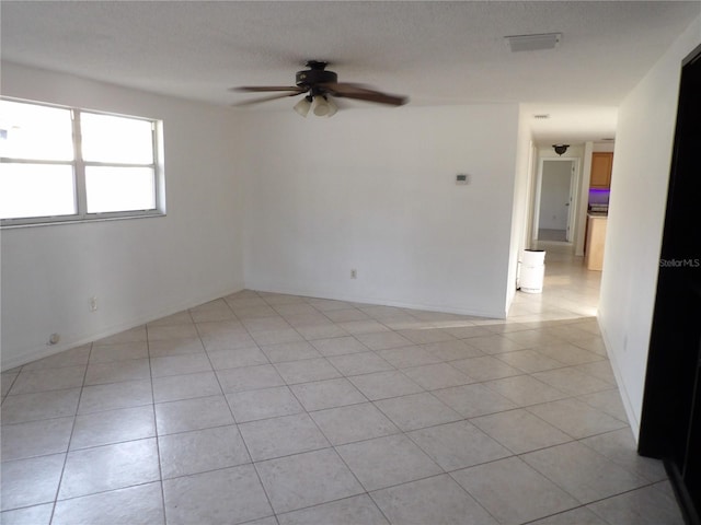 tiled spare room featuring a textured ceiling and ceiling fan