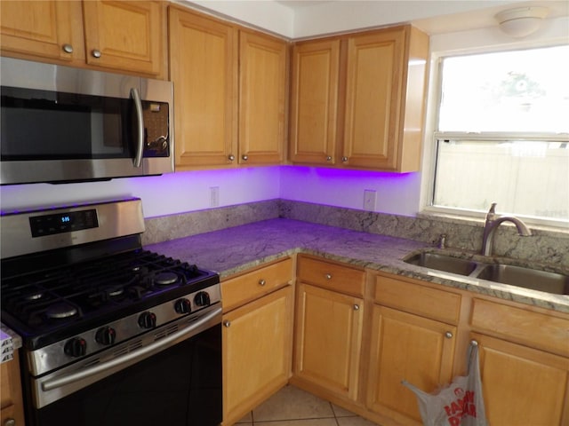 kitchen with stainless steel appliances, sink, and light tile patterned floors