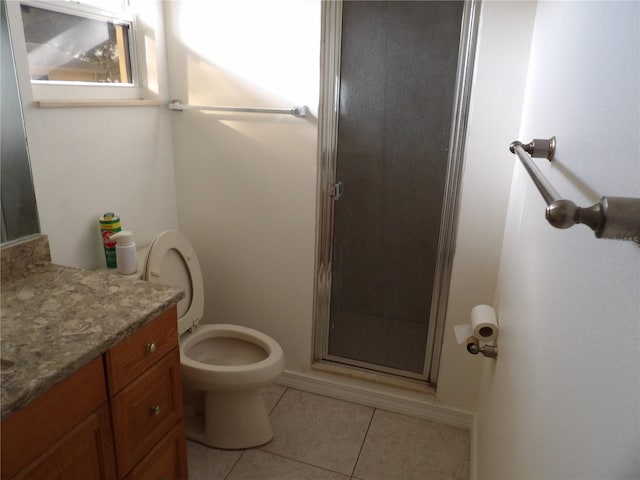 bathroom featuring vanity, a shower with shower door, tile patterned floors, and toilet