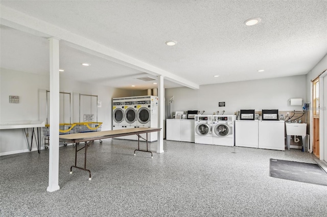 laundry room with sink, washer and clothes dryer, and a textured ceiling