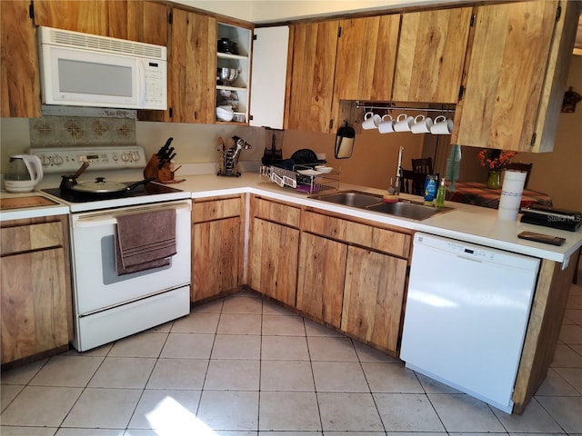 kitchen featuring light tile patterned flooring, sink, and white appliances