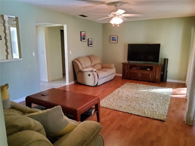 living room with light hardwood / wood-style floors and ceiling fan