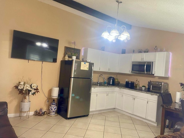 kitchen featuring hanging light fixtures, stainless steel appliances, white cabinets, and light tile patterned flooring