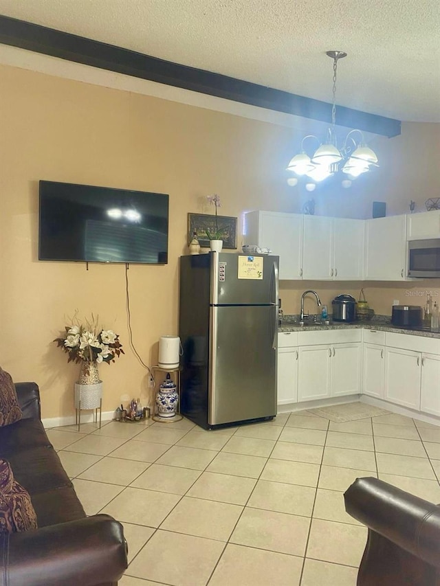 kitchen with white cabinetry, appliances with stainless steel finishes, light tile patterned floors, and decorative light fixtures