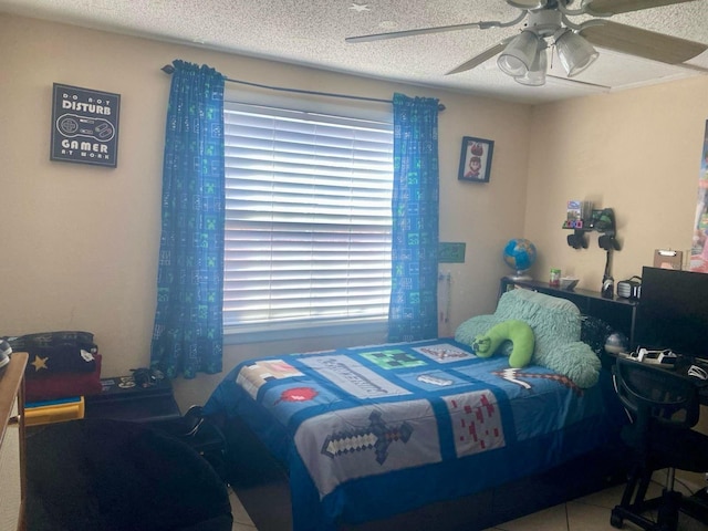 bedroom with tile patterned flooring, ceiling fan, and a textured ceiling