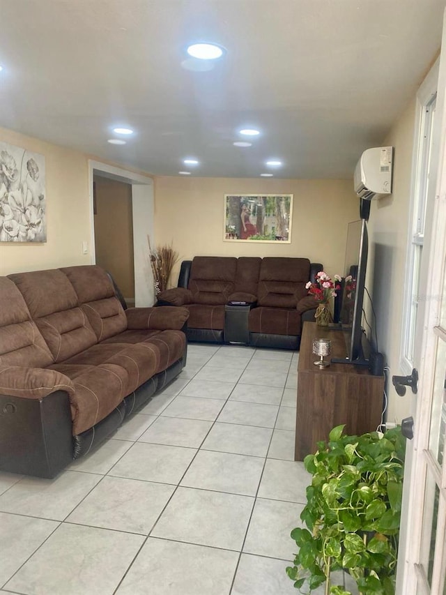 living room featuring an AC wall unit and light tile patterned floors