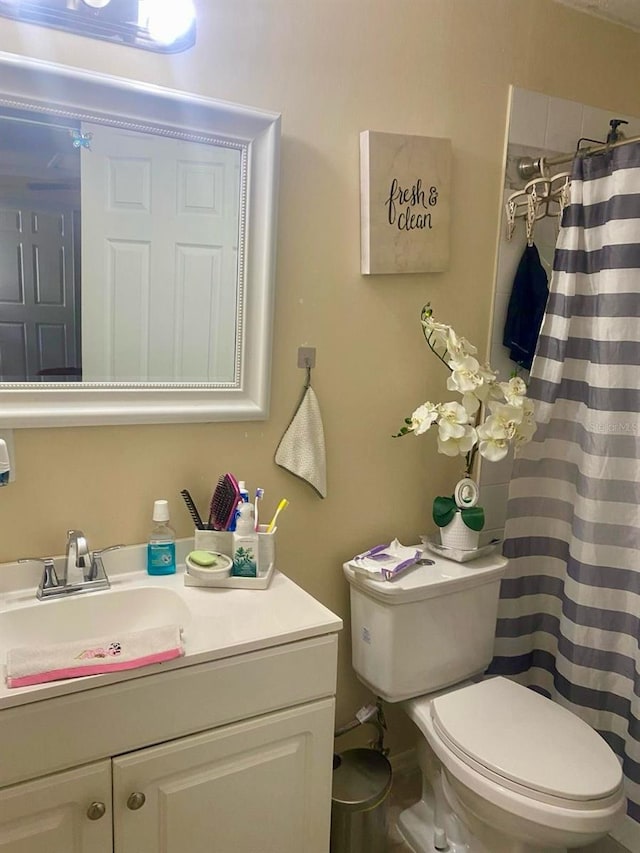 bathroom with vanity, a shower with shower curtain, and toilet