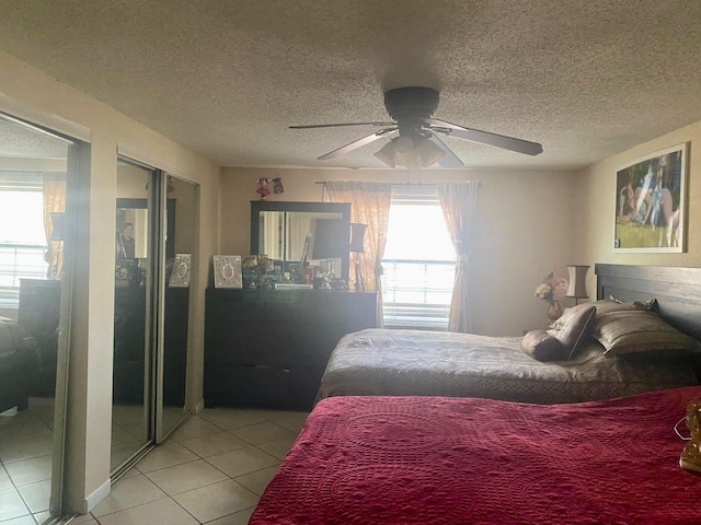 bedroom with ceiling fan, a textured ceiling, and light tile patterned floors