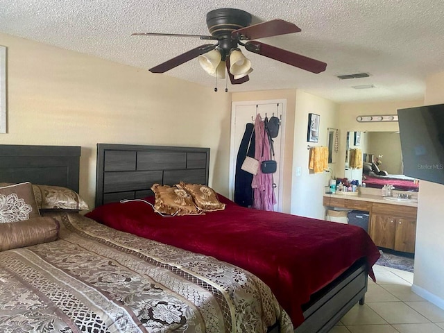 tiled bedroom featuring ceiling fan, a closet, and a textured ceiling