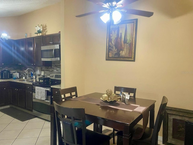 tiled dining room featuring sink and ceiling fan