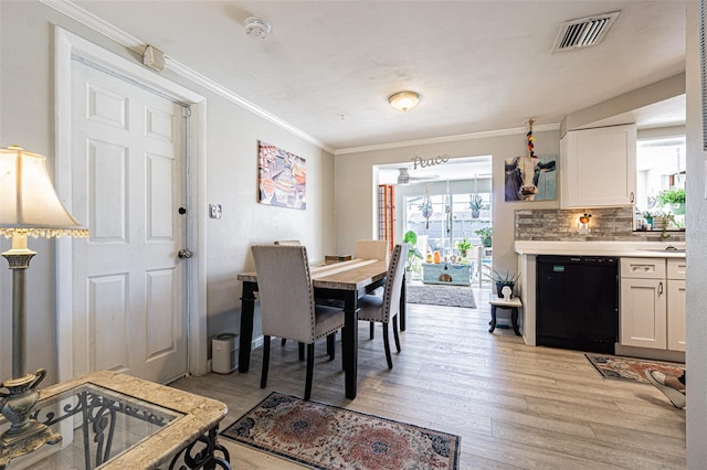 dining room featuring ornamental molding and light hardwood / wood-style floors