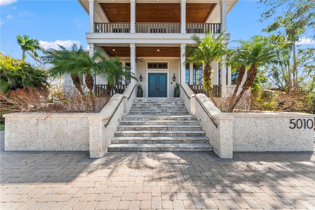 doorway to property with covered porch, french doors, and a balcony