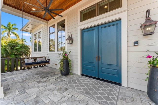 entrance to property featuring ceiling fan and a porch