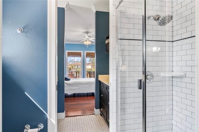 bathroom featuring vanity, crown molding, ceiling fan, and walk in shower