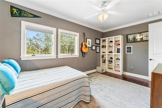 bedroom featuring ceiling fan, ornamental molding, wood finished floors, and baseboards