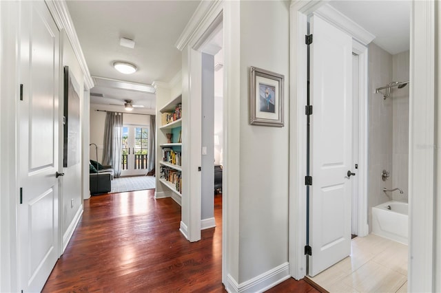 corridor featuring wood-type flooring and ornamental molding