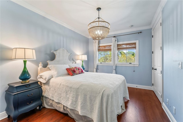 bedroom with a notable chandelier, crown molding, baseboards, and dark wood-style flooring