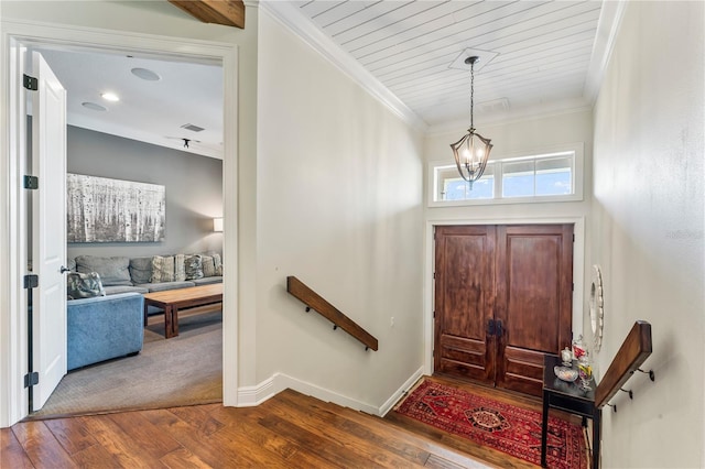 entryway featuring hardwood / wood-style flooring, ornamental molding, and a chandelier