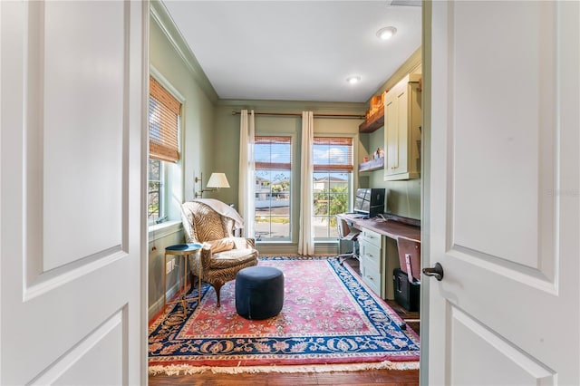 sitting room with a healthy amount of sunlight, built in desk, and wood finished floors