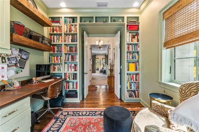 office area with dark hardwood / wood-style floors, built in desk, and a notable chandelier