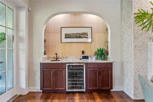 bar with dark wood-style floors, wine cooler, a sink, a healthy amount of sunlight, and indoor wet bar