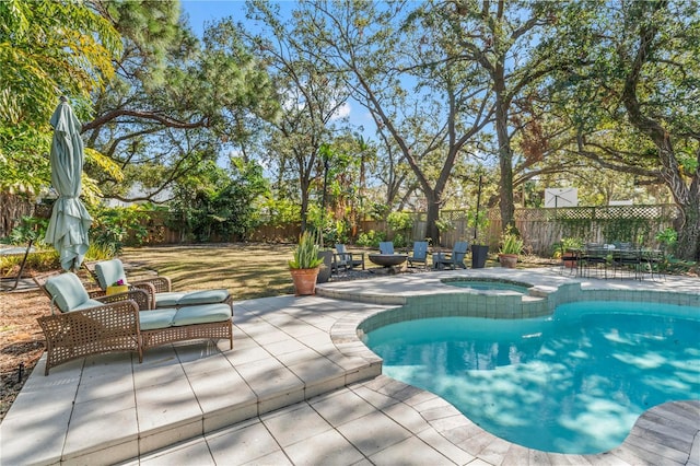 view of pool with a patio area, a fenced backyard, and a pool with connected hot tub