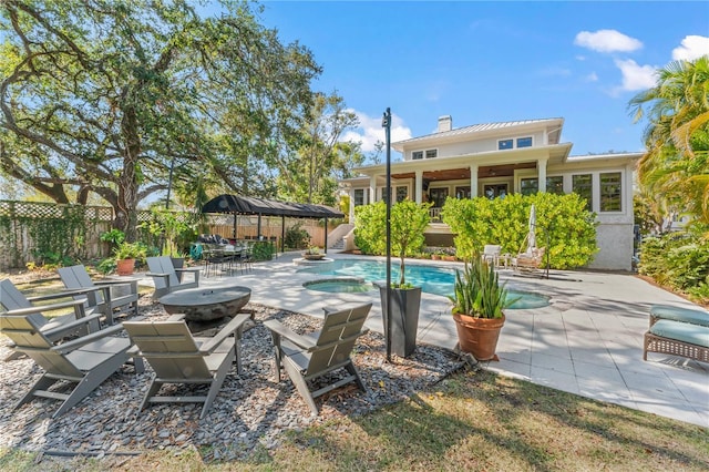 view of swimming pool featuring a fire pit, a patio, fence, and a fenced in pool