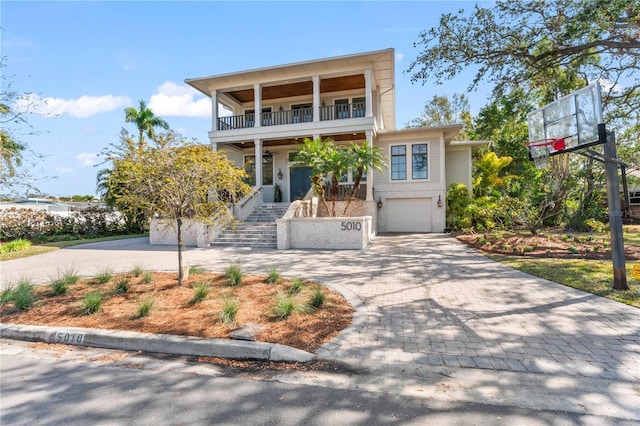 view of front of property with a garage, a balcony, and covered porch