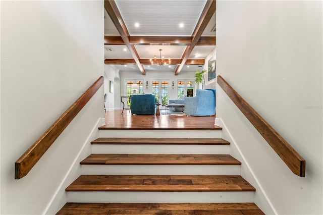 stairway featuring coffered ceiling, a notable chandelier, and beam ceiling