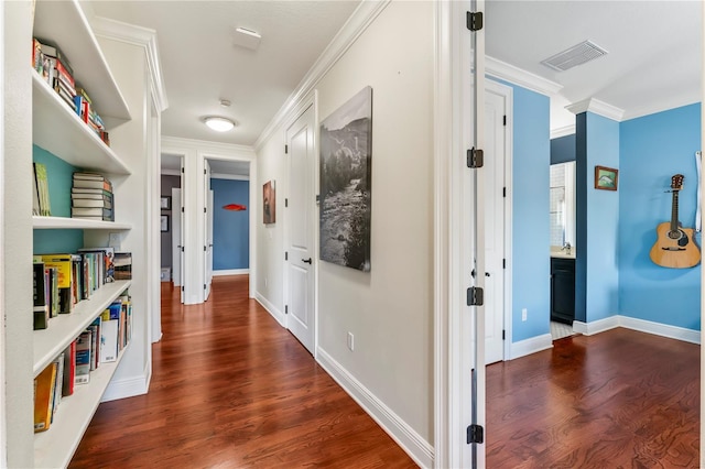 hallway featuring baseboards, visible vents, dark wood finished floors, and crown molding