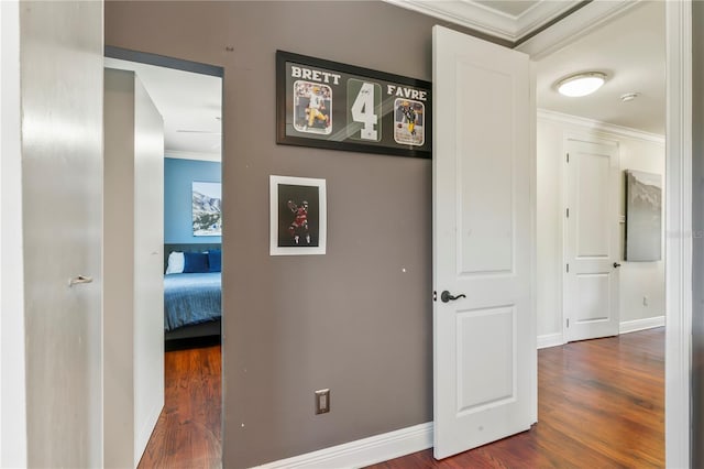 hallway with dark hardwood / wood-style flooring and ornamental molding