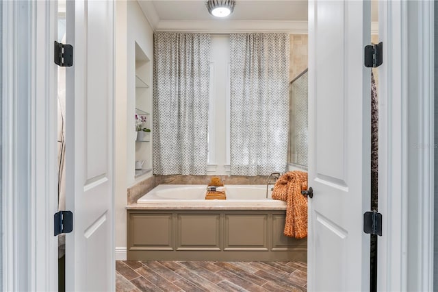 bathroom with wood tiled floor, ornamental molding, and a bath