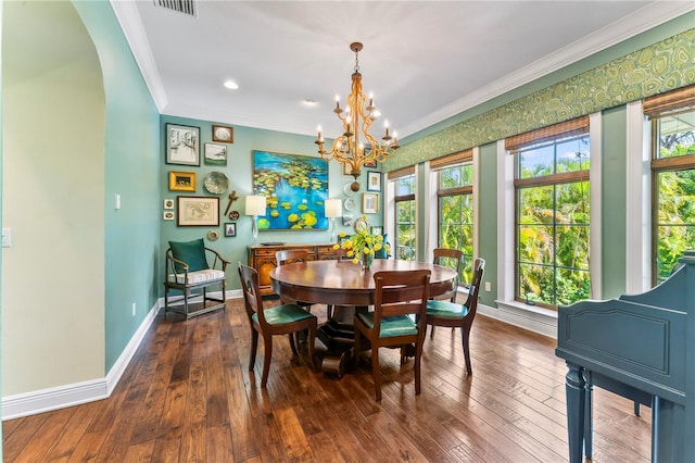 dining area with ornamental molding, an inviting chandelier, and dark hardwood / wood-style flooring