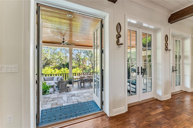 doorway with ornamental molding, beamed ceiling, hardwood / wood-style floors, and french doors