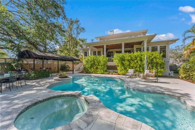 view of swimming pool featuring a patio area and an in ground hot tub