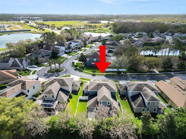 birds eye view of property with a water view and a residential view