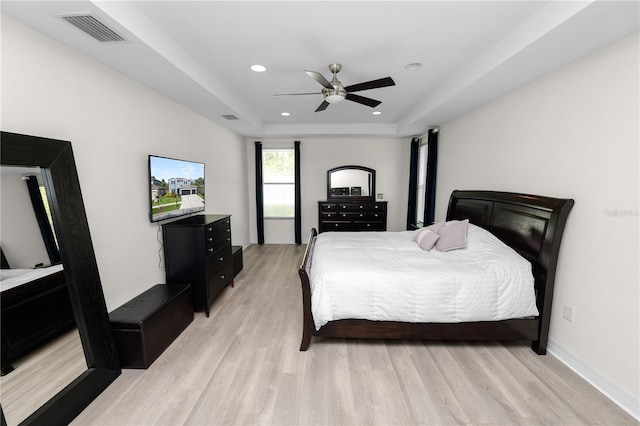 bedroom featuring a tray ceiling, recessed lighting, visible vents, a ceiling fan, and light wood-type flooring