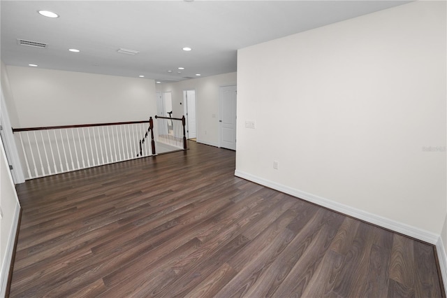 unfurnished room with baseboards, wood finished floors, visible vents, and recessed lighting