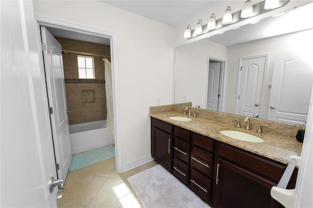 full bath featuring double vanity, baseboards, a sink, and tile patterned floors