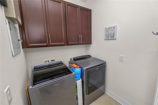 laundry area with washing machine and dryer, cabinet space, and baseboards