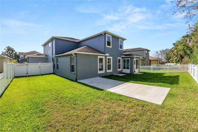 back of property featuring a fenced backyard, a yard, a patio, and stucco siding