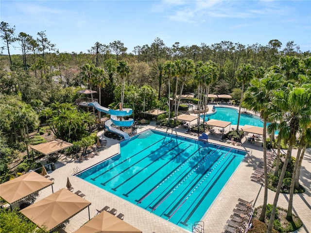 community pool featuring a patio area and a water slide