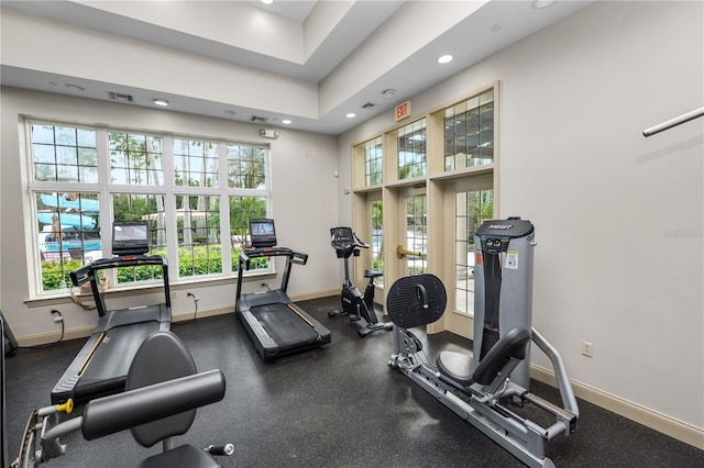 gym with recessed lighting, a towering ceiling, visible vents, and baseboards