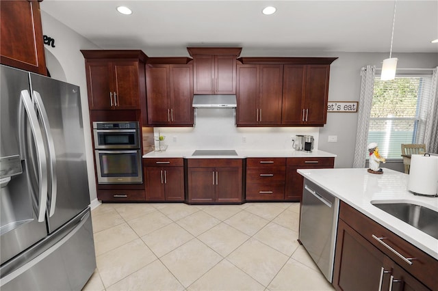 kitchen with light tile patterned floors, stainless steel appliances, light countertops, and under cabinet range hood